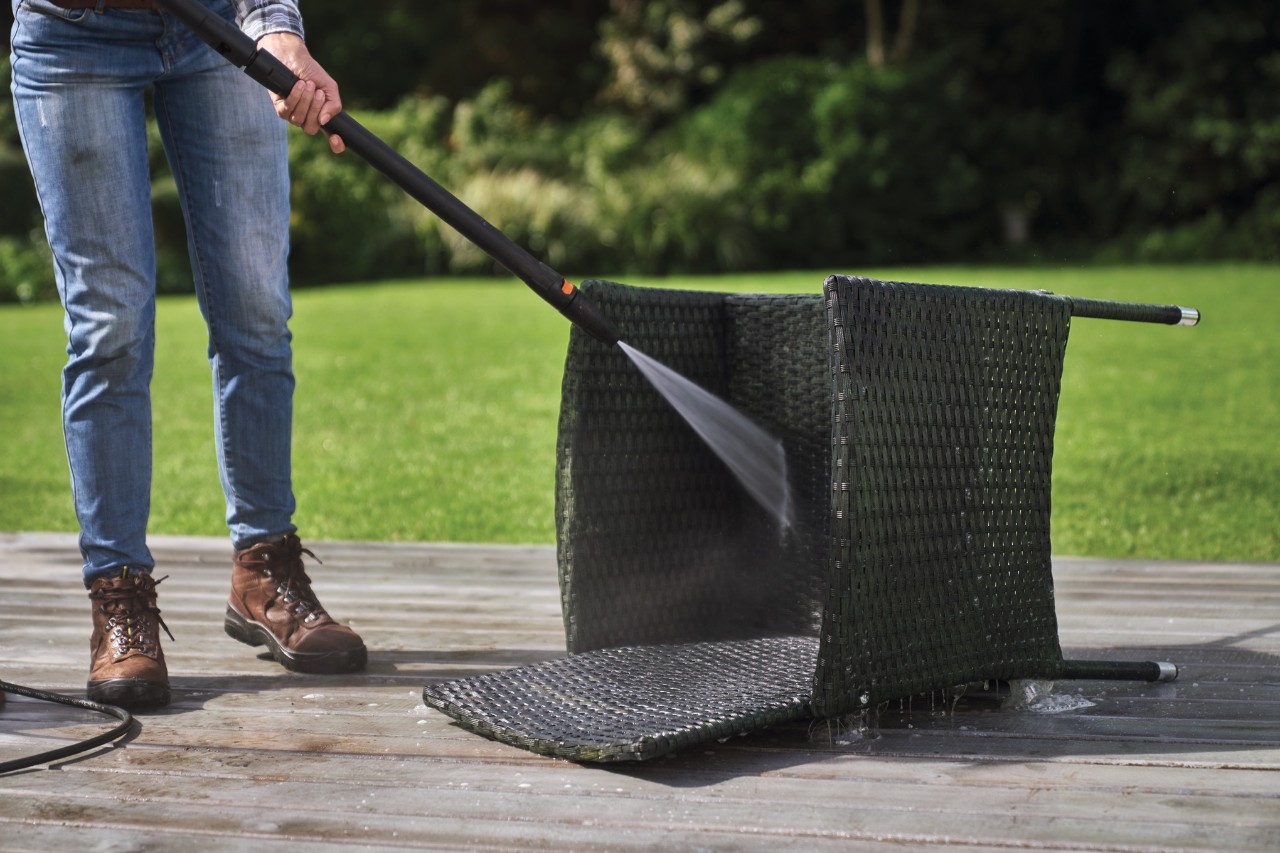 Rattanstuhl wird mit STIHL Hochdruckreiniger RE 130 plus gereinigt