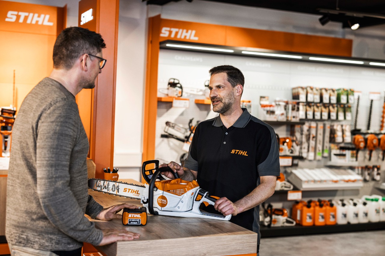 STIHL-Händler berät Kunden in seinem Verkaufsraum zur Akku-Kettensäge STIHL MSA 300