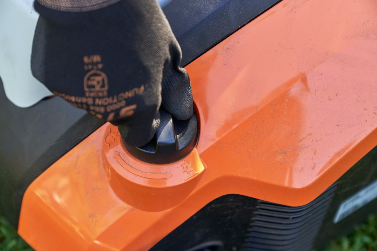 Gros plan : une main portant un gant de travail STIHL FUNCTION SENSOTOUCH tourne la poignée rotative de l’aérateur de pelouse sans fil STIHL RLA 240.
