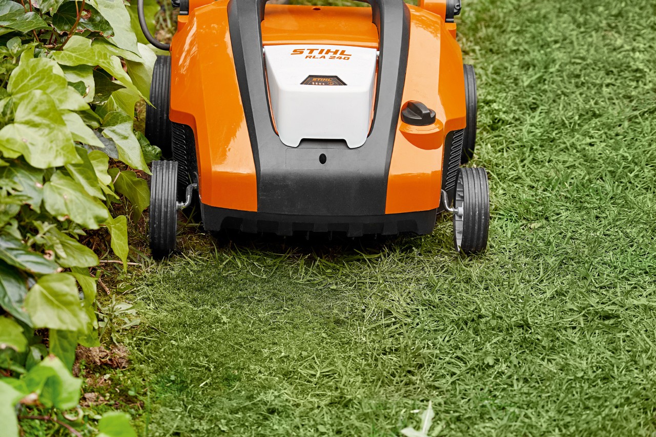 Gros plan sur le scarificateur à batterie STIHL RLA 240 devant le sable de pelouse