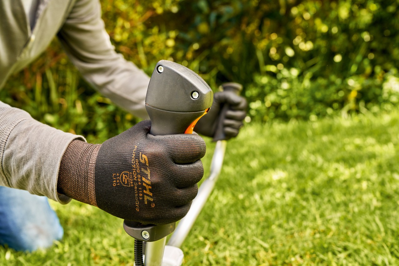 Un homme faisant démarrer brièvement le moteur de la débroussailleuse à essence STIHL FS 91