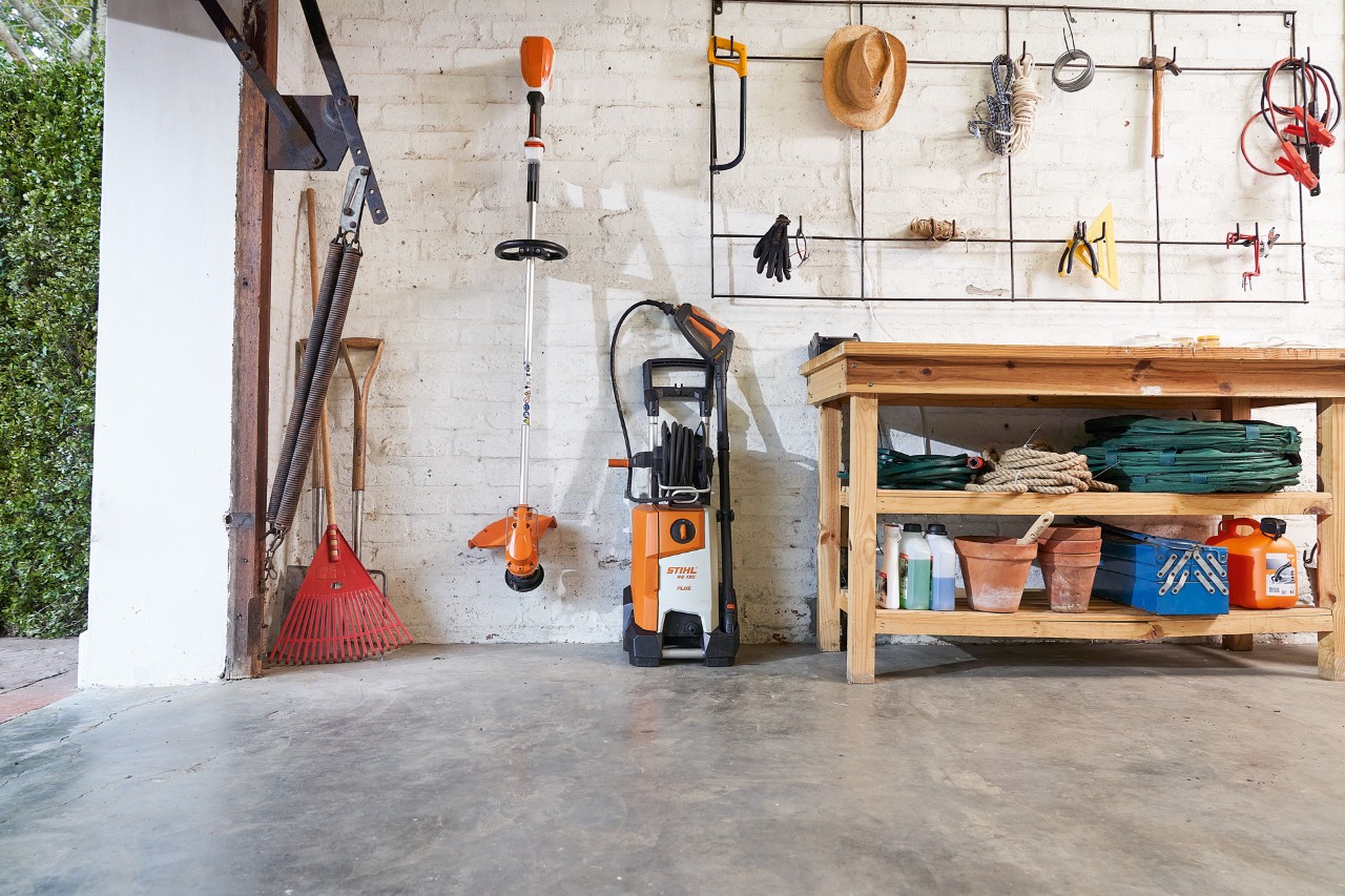 Nettoyeur haute pression STIHL RE 130 PLUS dans un garage avec d’autres appareils et outils