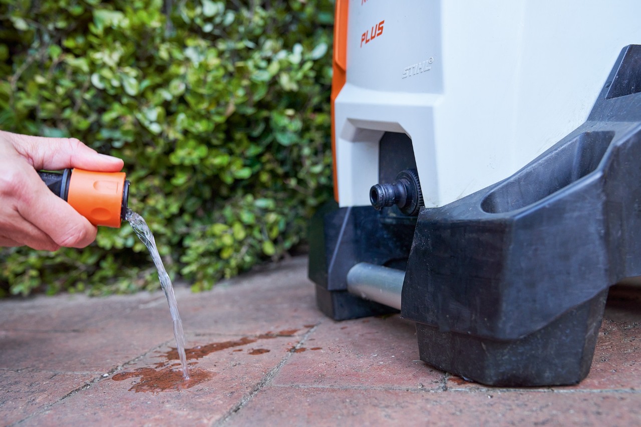 Une personne nettoyant le filtre d’arrivée d’eau du nettoyeur haute pression STIHL RE 130 PLUS dans le cadre de l’entretien ce dernier