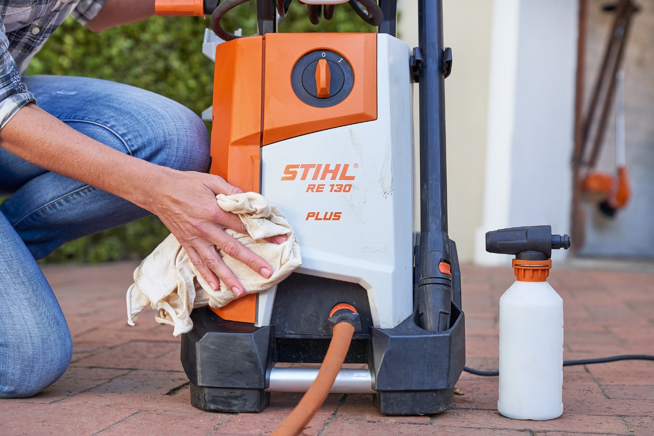 Une femme entretenant le nettoyeur haute pression STIHL RE 130 PLUS avec un antigel
