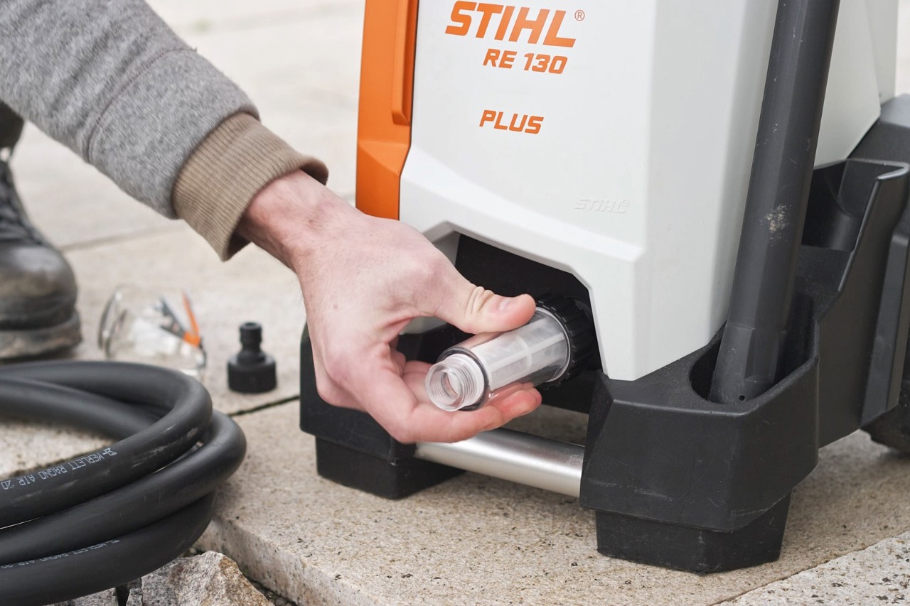 Une personne contrôlant le raccordement du nettoyeur haute pression STIHL RE 130 PLUS