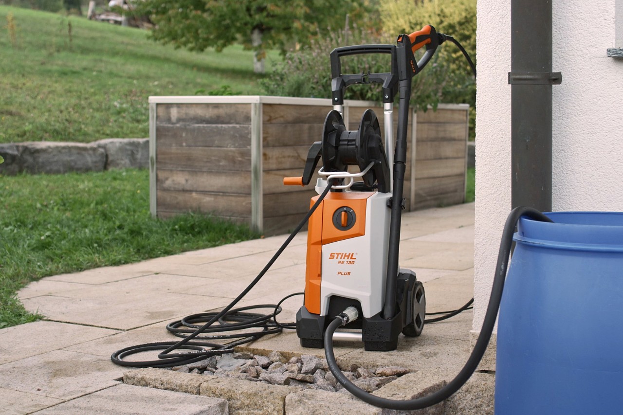 Le nettoyeur haute pression STIHL RE 130 PLUS raccordé, prêt à être utilisé sur une terrasse 