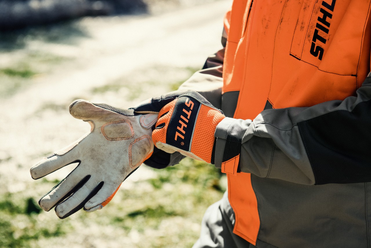 Gros plan d’une personne enfilant des gants de travail STIHL