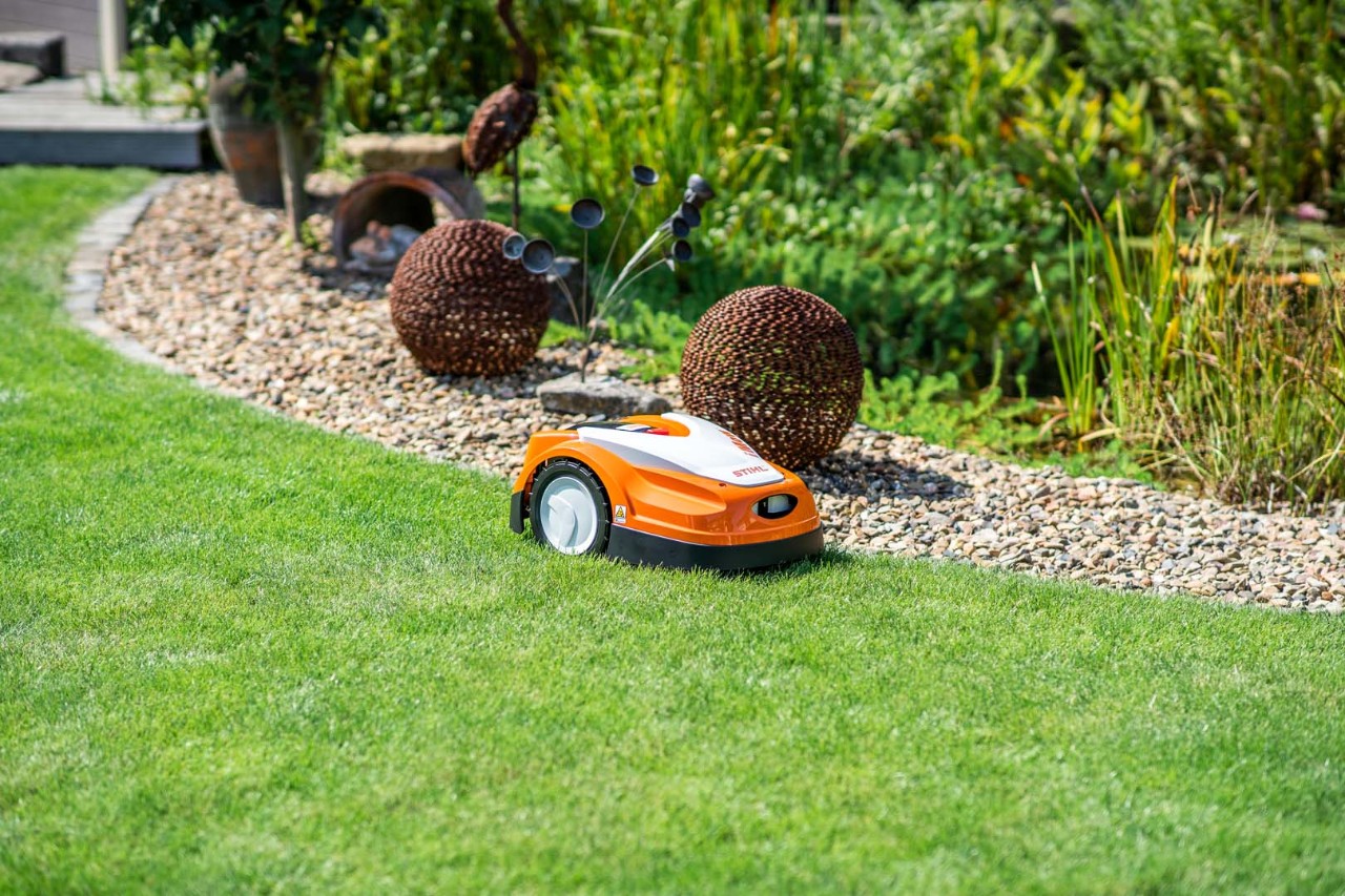 Robot de tonte STIHL iMOW® 422 avant son entretien sur un gazon vert