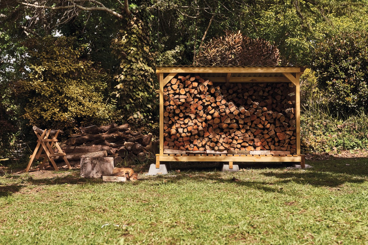 Abri à bois de chauffage construit soi-même dans un jardin