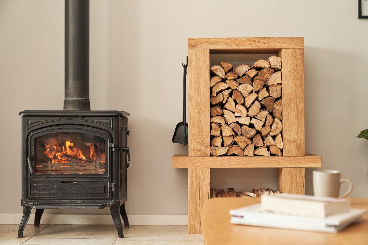 Meuble de rangement de bois de chauffage intérieur à côté d’une cheminée allumée