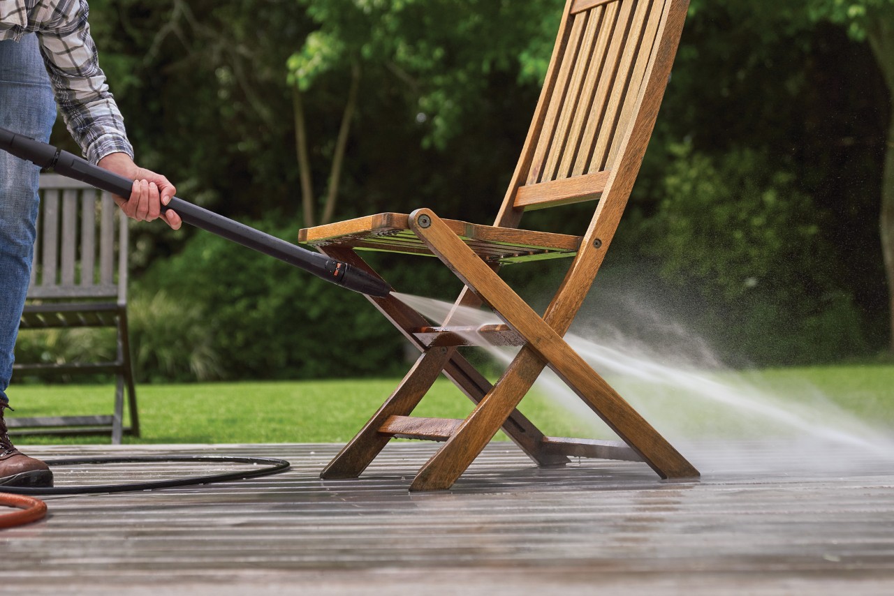 Siège de jardin en métal sur une terrasse, nettoyé au jet d’eau du nettoyeur haute pression STIHL RE 130 Plus