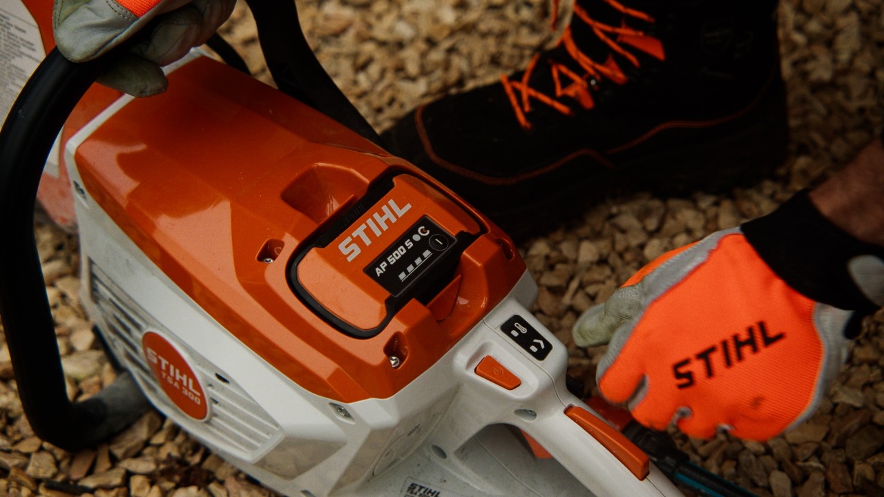 Gros plan du STIHL TSA 300, tronçonneuse à disque à batterie avec batterie AP 500 S, appareil professionnel robuste avec poignée ergonomique et éléments de commande pour des travaux de coupe précis en extérieur