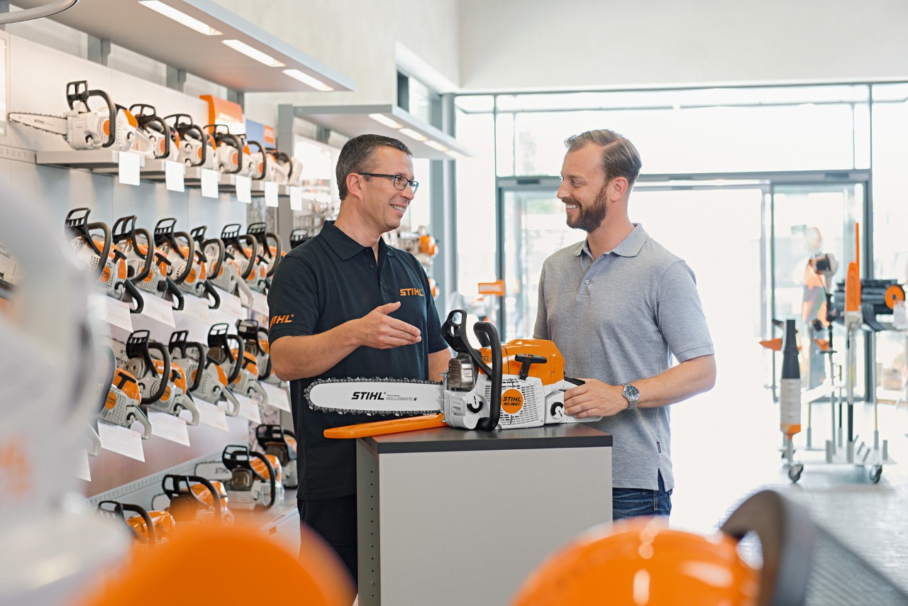 Le revendeur spécialisé STIHL conseille l'homme lors de l'achat d'une tronçonneuse STIHL