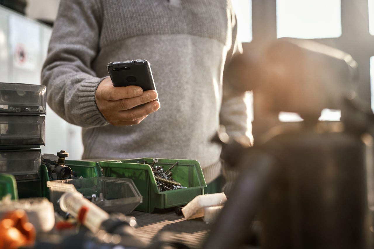 Persona con lo smartphone in un'officina