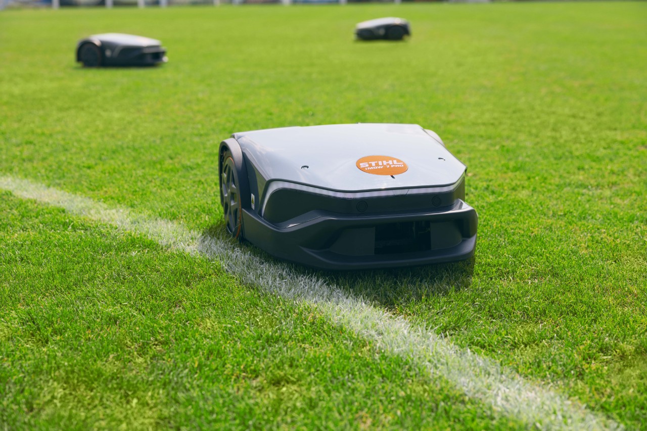 Tre robot tosaerba iMOW® 7 Pro su un campo sportivo