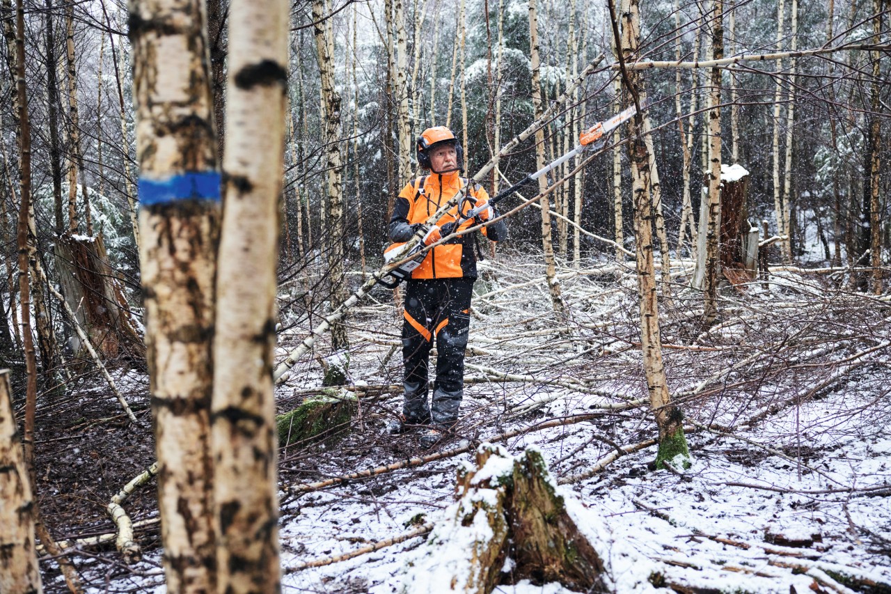 Un uomo in attrezzatura da lavoro protettiva nella foresta