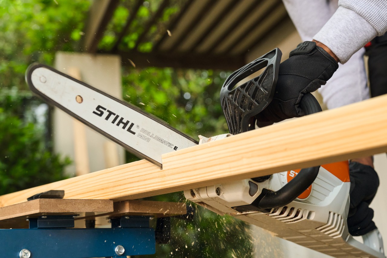 Un uomo sega un montante laterale per una porta da calcio con una motosega STIHL MSA 70