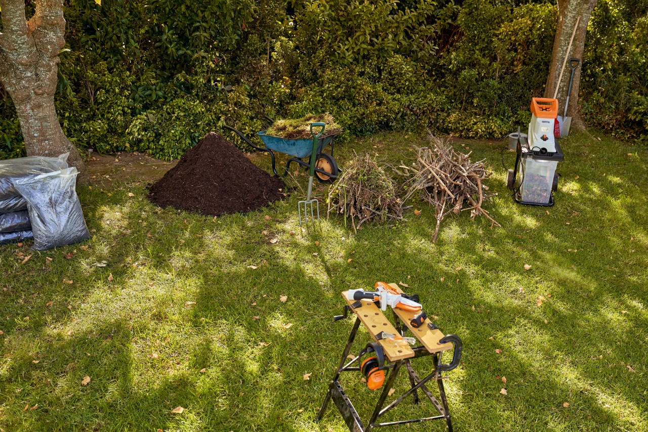 Biotrituratore elettrico da giardino STIHL GHE 140, residui di potatura e compost all'interno di un giardino