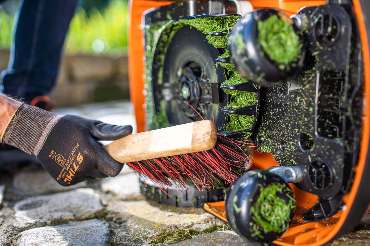 Per eliminare i residui di erba dal piatto del robot tosaerba utilizzare una spazzola