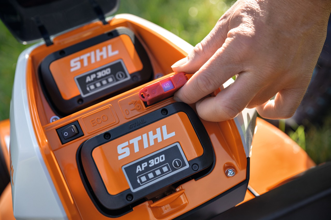 Una persona inserisce un connettore di sicurezza nel tosaerba a batteria STIHL RMA 448 VC 