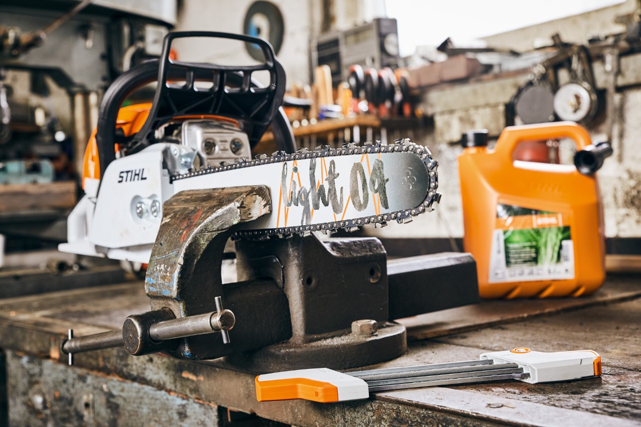 Motosega a benzina STIHL MS 261 C-M con spranga di guida Light 04 accanto alla miscela di carburante STIHL 