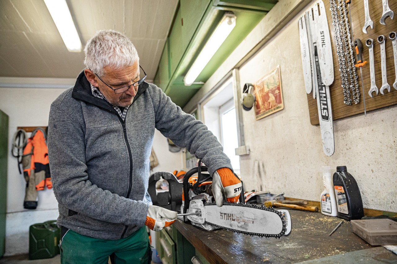 Uomo che tende la catena di una motosega STIHL
