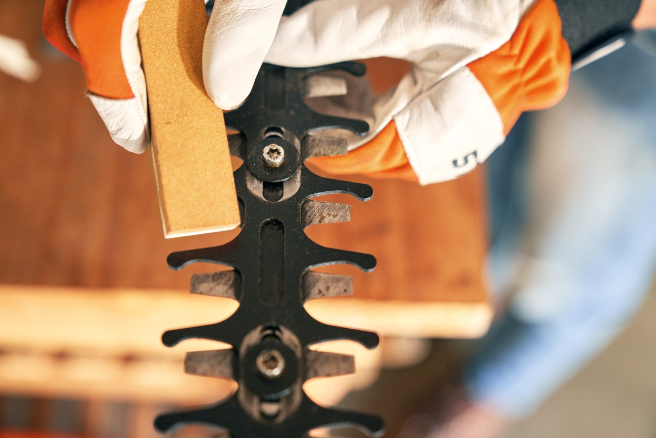 Rimozione delle bave dal tosasiepi senza fili STIHL HSA 56 effettuata con una pietra per affilatura