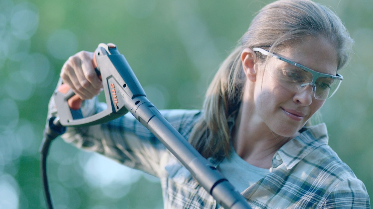 Donna che pulisce i mobili da giardino con un'idropulitrice STIHL