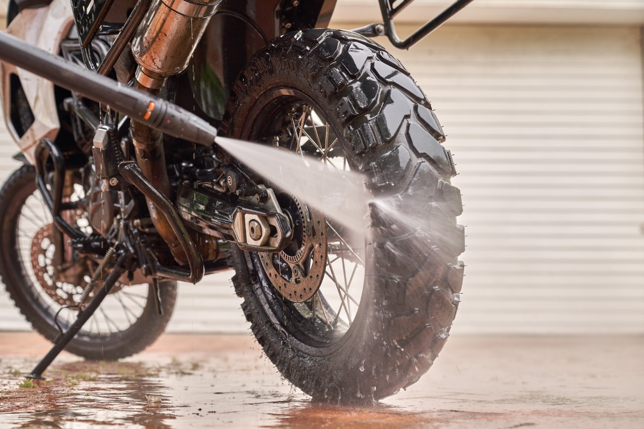 Ruota posteriore di una moto che viene risciacquata con l'idropulitrice
